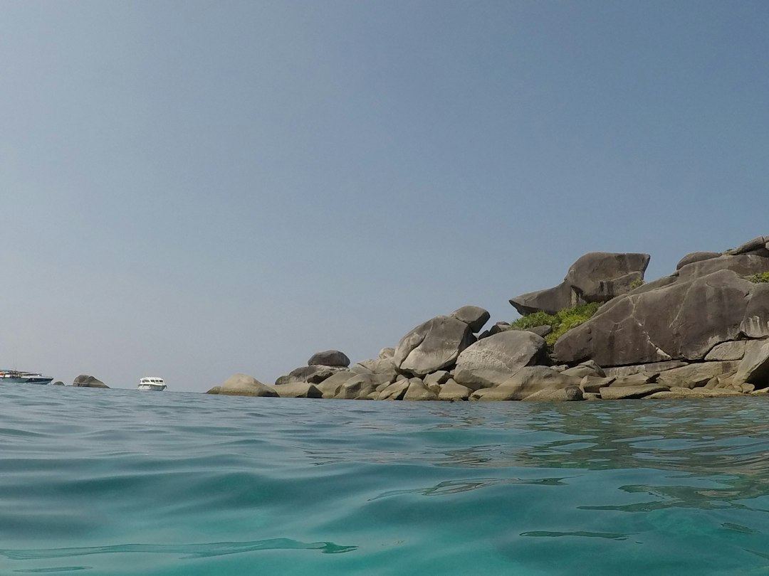 Khao Lak: a rocky shoreline with a boat in the water**
